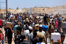 Người dân Palestine mang theo hàng viện trợ mà họ nhận được từ Quỹ Nhân đạo Gaza do Mỹ hậu thuẫn, tại trung tâm Dải Gaza, ngày 29/5. Ảnh: Reuters.