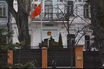 Một người phụ nữ đi ngang qua tòa nhà Đại sứ quán Trung Quốc tại Kiev vào ngày 8/4. Ảnh: AFP.
