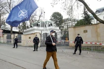 Một người đàn ông mang cờ NATO trước cửa Đại sứ quán Nga ở Praha, CH Séc (Ảnh: RT)