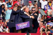 Ông Donald Trump được các nhân viên mật vụ che chắn sau nhiều tiếng súng nổ (Ảnh: CNN)