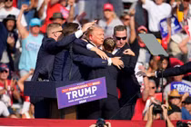 Ông Donald Trump được các nhân viên mật vụ che chắn sau nhiều tiếng súng nổ (Ảnh: CNN)