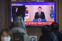 Người dân xem màn hình TV phát sóng Tổng thống Hàn Quốc Yoon Suk Yeol phát biểu trước quốc tại nhà ga ở Seoul, Hàn Quốc ngày 12/12. Ảnh: Reuters.