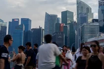 Du khách đến Vịnh Marina đi bộ trên cây cầu nhìn ra Khu thương mại trung tâm ở Singapore (Ảnh: Getty)