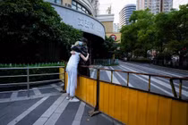 Hai cô gái đứng ôm nhau qua hàng rào, giữa lúc phong tỏa tại thành phố Thượng Hải, ngày 16/5 (Ảnh: SCMP)