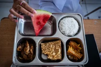 Một học sinh trung học cơ sở ở Bandung, Indonesia cùng khay thức ăn được cung cấp như một phần trong chương trình bữa ăn miễn phí của nước này. Ảnh: CNA.