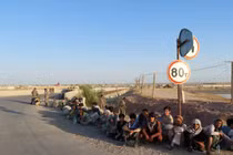 Các binh sĩ Afghanistan ngồi bên một cây cầu gần biên giới với Tajiskistan hồi tháng 6/2021 (Ảnh: AP)