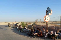 Các binh sĩ Afghanistan ngồi bên một cây cầu gần biên giới với Tajiskistan hồi tháng 6/2021 (Ảnh: AP)