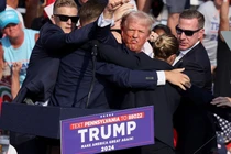 Ông Donald Trump ra hiệu với khuôn mặt đầy máu sau khi bị bắn vào tai phải trong một cuộc vận động tranh cử ở Butler, Pennsylvania, Mỹ ngày 13/7/2024. Ảnh: Reuters.