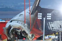 Lính cứu hỏa và nhân viên cứu hộ làm việc gần hiện trường vụ máy bay Boeing 737-800 của Jeju Air tại Sân bay quốc tế Muan vào ngày 29/12. Ảnh: AFP.