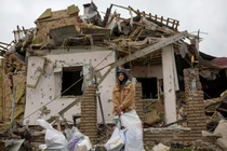 Một người phụ nữ đứng cùng đồ đạc của mình bên ngoài ngôi nhà của cô ở Markhalivka, thuộc khu vực Kiev của Ukraine, nơi đã bị phá hủy trong cuộc không kích của Nga vào hôm 25/5. Ảnh: Reuters.