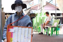 Một người bán vé số tại đường Ti Thong ở Bangkok, Thái Lan. Ảnh: Bangkok Post.