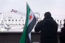 Người Syria tị nạn phản ứng trước những diễn biến mới ở Syria tại Ga trung tâm Duisburg ở Duisburg, Đức. Ảnh: Getty.