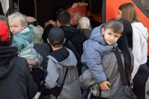 Người tị nạn từ Ukraine đứng cạnh một chiếc xe buýt tại trung tâm tiếp nhận người tị nạn đầu tiên ở Hesse, Đức. Ảnh: Getty.