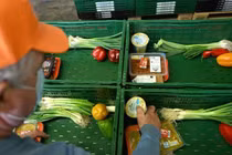 Một tình nguyện viên đang sắp xếp thực phẩm vào các giỏ hàng tại Bochum, Đức (Ảnh: AFP)