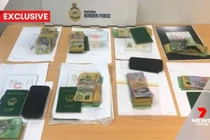 Hình ảnh từ bản tin của 7News thể hiện rõ các cuốn hộ chiếu mang quốc huy Việt Nam trong tang vật vụ việc. (Ảnh cắt từ clip)