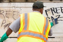 Các nhân viên Dịch vụ Công viên Quốc gia ở Mỹ cố gắng xóa những bức vẽ graffiti ủng hộ Palestine sau một cuộc biểu tình, ngày 25/7 (Ảnh: Getty)