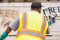 Các nhân viên Dịch vụ Công viên Quốc gia ở Mỹ cố gắng xóa những bức vẽ graffiti ủng hộ Palestine sau một cuộc biểu tình, ngày 25/7 (Ảnh: Getty)