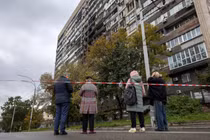 Người dân ở thủ đô Kiev, Ukraine đứng trước một tòa nhà bị hư hại trong sáng 10/10. Ảnh: Reuters.