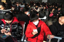 Nhiều hành khách mang khẩu trang khi chờ tàu tại Trạm đường sắt phía Tây để bắt tàu tới Vũ Hán (Ảnh: Reuters)