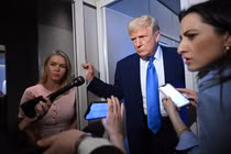 Thư ký báo chí Nhà Trắng Karoline Leavitt lắng nghe khi Tổng thống Donald Trump phát biểu với các phóng viên trong chuyến bay trên Không lực Một ngày 6/4. Ảnh: AFP.