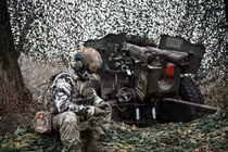 Một quân nhân Nga ngồi cạnh một khẩu pháo ở Vùng Kursk, Nga ngày 5/11 (Ảnh: Sputnik)