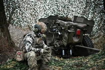 Một quân nhân Nga ngồi cạnh một khẩu pháo ở Vùng Kursk, Nga ngày 5/11 (Ảnh: Sputnik)