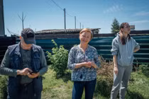 Vadym Smirnov, Alla Voloshynovych cô con gái Anastasia Smirnov đứng trên mảnh vườn đã được dọn gần hết mảnh đạn (Ảnh: Al Jazeera)