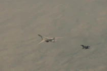 Máy bay ném bom Tu-160 của Nga được hộ tống bởi một chiếc Su-30SM (Ảnh: RT)