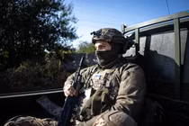 Một người lính Ukraine ngồi sau xe trên đường ra mặt trận ở Donetsk (Ảnh: Getty)