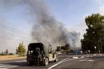 Một chiếc xe jeep của quân đội Israel đậu gần trạm kiểm soát khi khói bốc lên từ đám cháy do tên lửa phóng từ miền nam Lebanon, ở Thượng Galilee, Israel ngày 4/7/2024 (Ảnh: AFP)