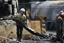Lực lượng cứu hộ và công nhân dọn dẹp các mảnh vỡ trong phòng tuabin sau cuộc tấn công vào một nhà máy điện ở một địa điểm không được tiết lộ ở Ukraine (Ảnh: AFP)