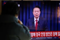 Một người dân xem buổi phát sóng Tổng thống Hàn Quốc Yoon Suk Yeol phát biểu trước toàn quốc tại một nhà ga ở Seoul, Hàn Quốc, ngày 7/12. Ảnh: Reuters.