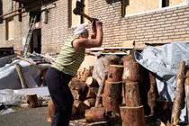 Một phụ nữ Ukraine chặt củi bên ngoài căn hộ của mình (Ảnh: Getty)