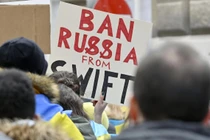 Người biểu tình giơ tấm biển "Loại Nga khỏi SWIFT" trước Đại sứ quán Nga tại Vienna, Áo (Ảnh: AFP)