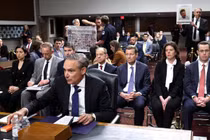 Tổng giám đốc điều hành Boeing Kelly Ortberg làm chứng trước một ủy ban Thượng viện khi những người biểu tình giơ cao các tấm biển mô tả các nạn nhân của vụ tai nạn 737 MAX. Ảnh: Getty.