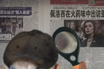 Một người dân đọc tin về bà Pelosi trên tờ Thời báo Hoàn cầu tại một sạp báo ở Bắc Kinh (Ảnh: AP)