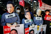 Người biểu tình đeo mặt nạ có hình Tổng thống Hàn Quốc Yoon Suk Yeol, cựu Bộ trưởng Quốc phòng Kim Yong-hyun và Choo Kyung-ho khi tập trung trước Quốc hội để yêu cầu luận tội ông Yoon. Ảnh: Reuters.