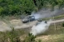 Ảnh cắt từ clip cho thấy xe chiến đấu Bradley do Mỹ cung cấp bắn vào xe bọc thép chở quân Nga (Ảnh: Business Insider)