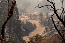 Một chiếc ô tô bị cháy nằm giữa tàn tích của những ngôi nhà sau vụ cháy Palisades ở khu Pacific Palisades, Los Angeles, California, Mỹ. Ảnh: Reuters.