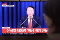 Một người dân theo dõi Tổng thống Yoon Suk Yeol tuyên bố thiết quân luật vào tối 3/12 tại ga Seoul. Ảnh: Yonhap.