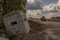 Binh sĩ Ukraine lái xe quân sự bọc thép đi qua cửa khẩu biên giới với Nga đã bị phá hủy ở vùng Sumy vào ngày 14/8/2024 (Ảnh: AFP)