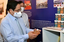 Thủ tướng xem và nghe giới thiệu về một sản phẩm KHCN bảo vệ sức khoẻ.