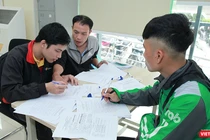 Nhân viên Bưu điện hướng dẫn khách hàng làm thủ tục đăng ký cấp phiếu lý lịch tư pháp tại bưu cục Thăng Long.