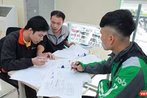 Nhân viên Bưu điện hướng dẫn khách hàng làm thủ tục đăng ký cấp phiếu lý lịch tư pháp tại bưu cục Thăng Long.