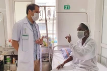 Bác sĩ Trung tâm Bệnh nhiệt đới Bệnh viện Bạch Mai trò chuyện, động viên bệnh nhân bị sốt rét ác tính trong những ngày điều trị (ảnh BV cung cấp)