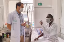 Bác sĩ Trung tâm Bệnh nhiệt đới Bệnh viện Bạch Mai trò chuyện, động viên bệnh nhân bị sốt rét ác tính trong những ngày điều trị (ảnh BV cung cấp)