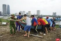 Lực lượng công an hỗ trợ người dân đưa tàu thuyền lên bờ tránh bão