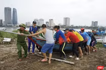 Lực lượng công an hỗ trợ người dân đưa tàu thuyền lên bờ tránh bão