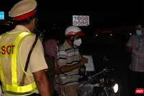 Một người dân được lực lượng liên ngành nhắc nhở, giải thích lúc 18h45' ngày 26/7 tại chống kiểm soát liên ngành trên đường Đỗ Xuân Hợp, TP Thủ Đức (TP.HCM). Ảnh:GVT.