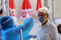 Nhân viên y tế kiểm tra nhiệt độ cho người dân (Ảnh - BYT) 